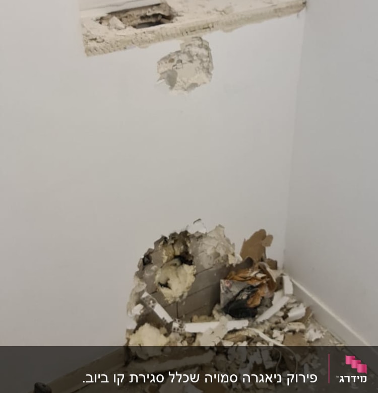 קיר עם חור ושברי טיח על הרצפה